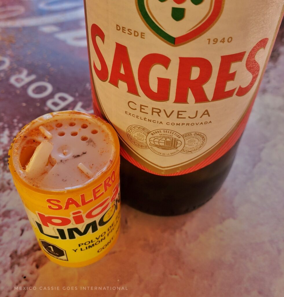 yellow tub (salero pico limon) next to a Sagres beer bottle