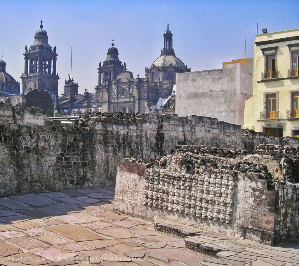 ancient wall of skulls, and Mexico City Cathedral behind