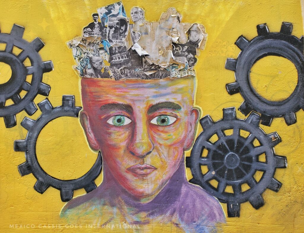 street art: picture of human head with newspaper for hair. cogs on either side of the face