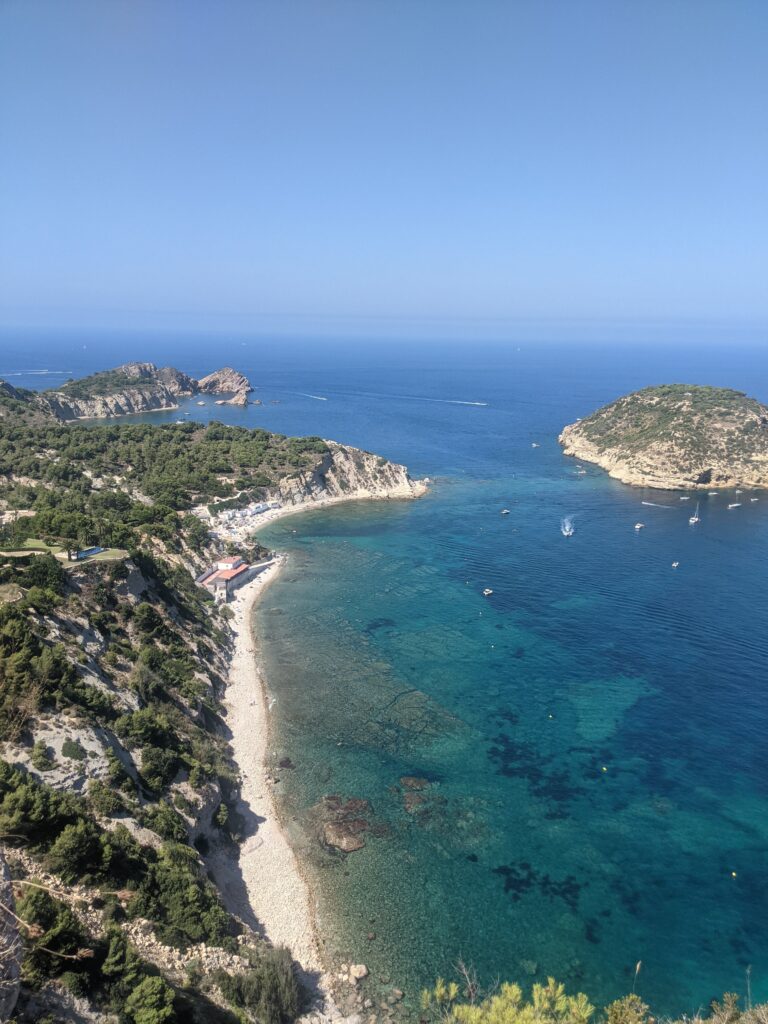 view from above of a long stretch of beach and cliff shore