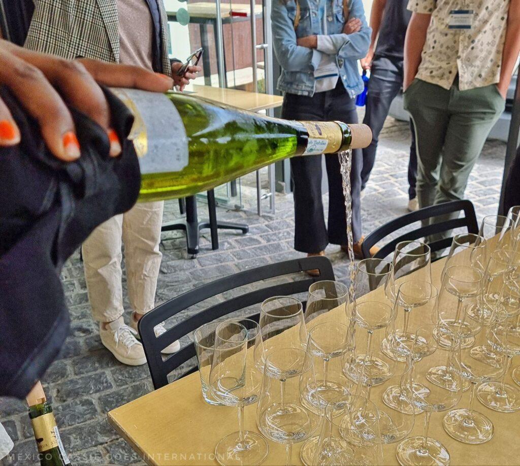 wine being poured into a group of empty glasses