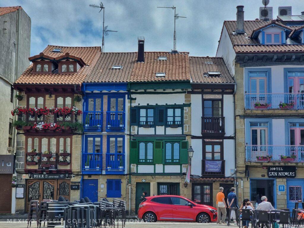 very old narrow houses, modern red car parked out front