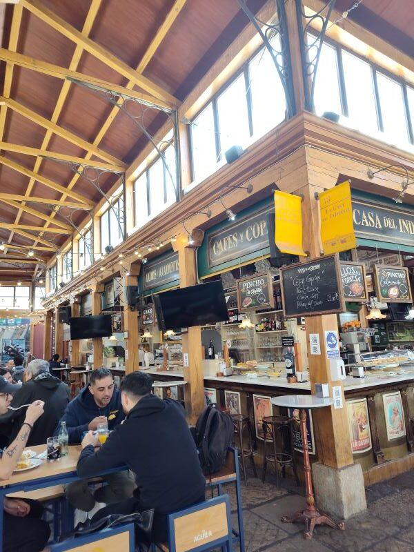 Spanish market scene - bars on rights and people sitting on left