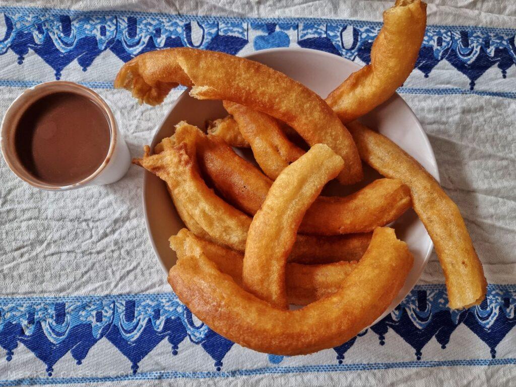 plate of churros and cup of dipping chocolate