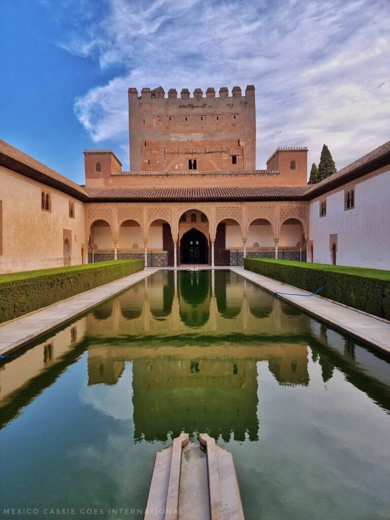 view of one of the Nasrid Palace courtyards with a perfect reflection in water