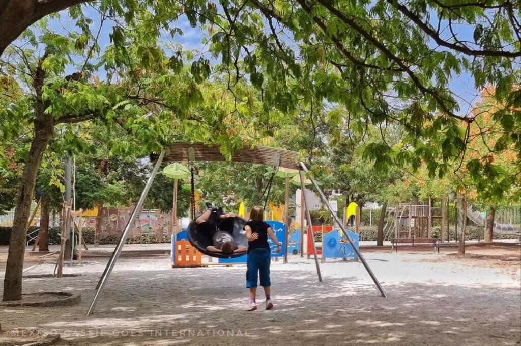 playground, 2 kids playing in a basket swing