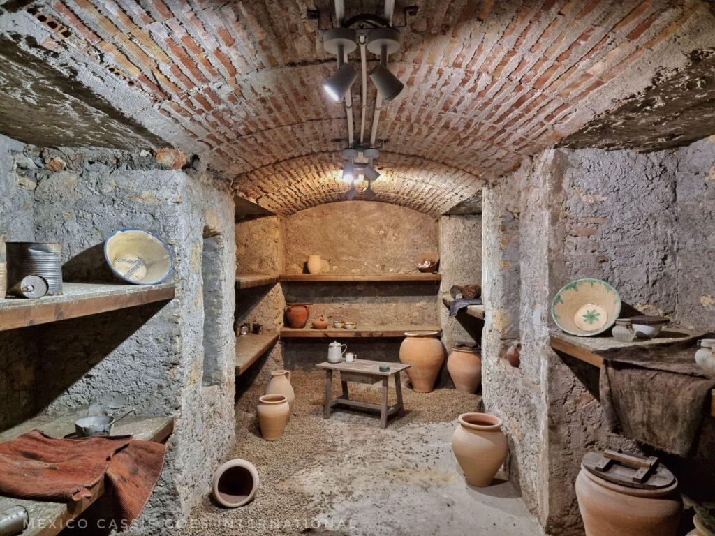 view of an abandoned air raid shelter, pots on floor, low ceilings