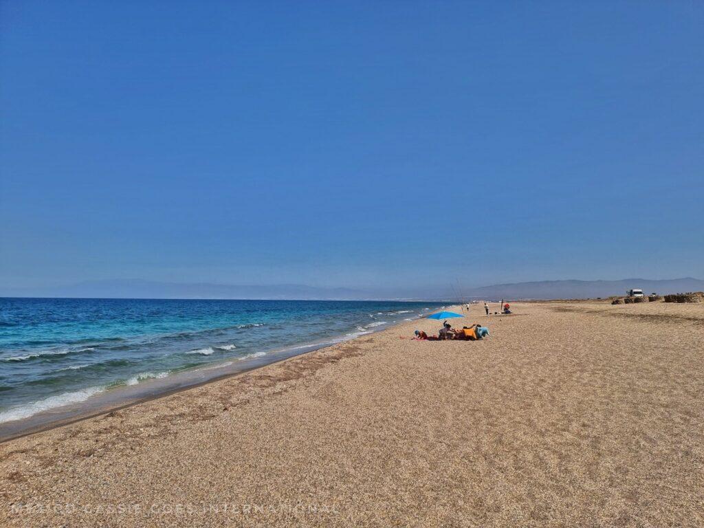 long, almost empty stretch of sandy beach and blue sea