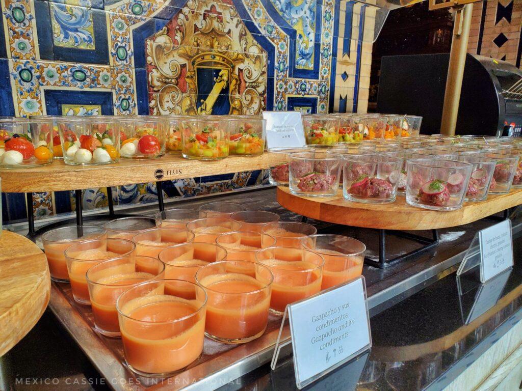 buffet table - foreground is tray with glasses full of gazpacho