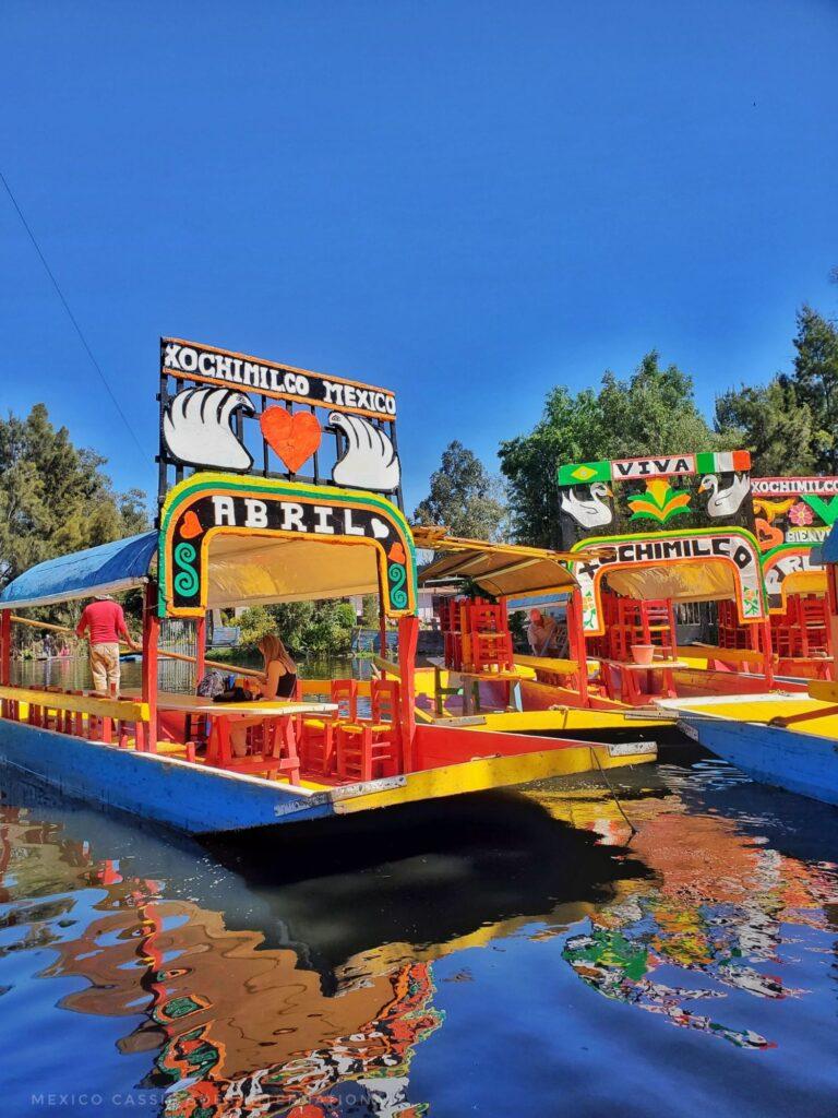 calm canal with red & yellow barge on it. clear reflection of boat