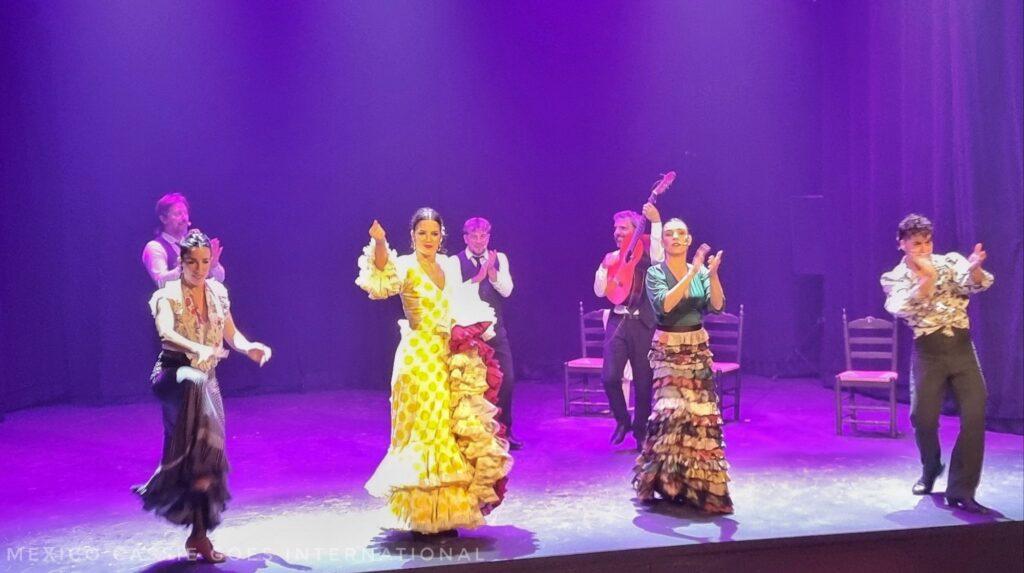 4 flamenco dancers in a row on a purple lit stage