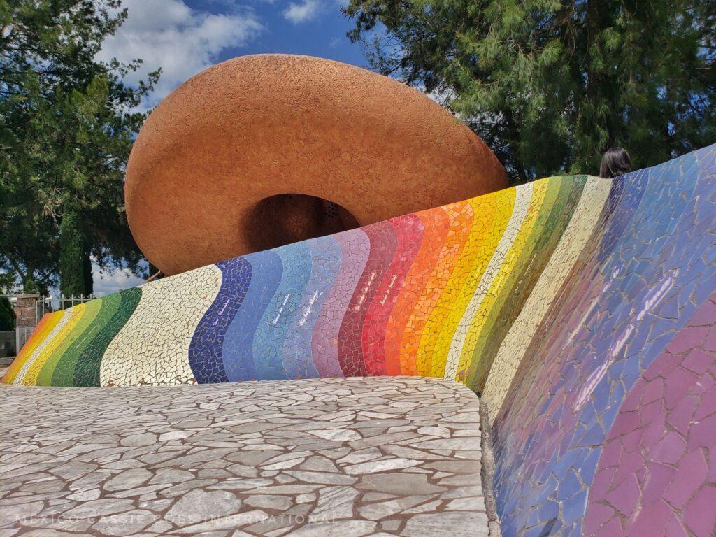 brightly coloured large striped 'wave' in front of a giant mexican hat