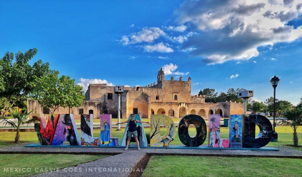 colourful giant letters spelling out 'Valladolid' - old convent building behind.