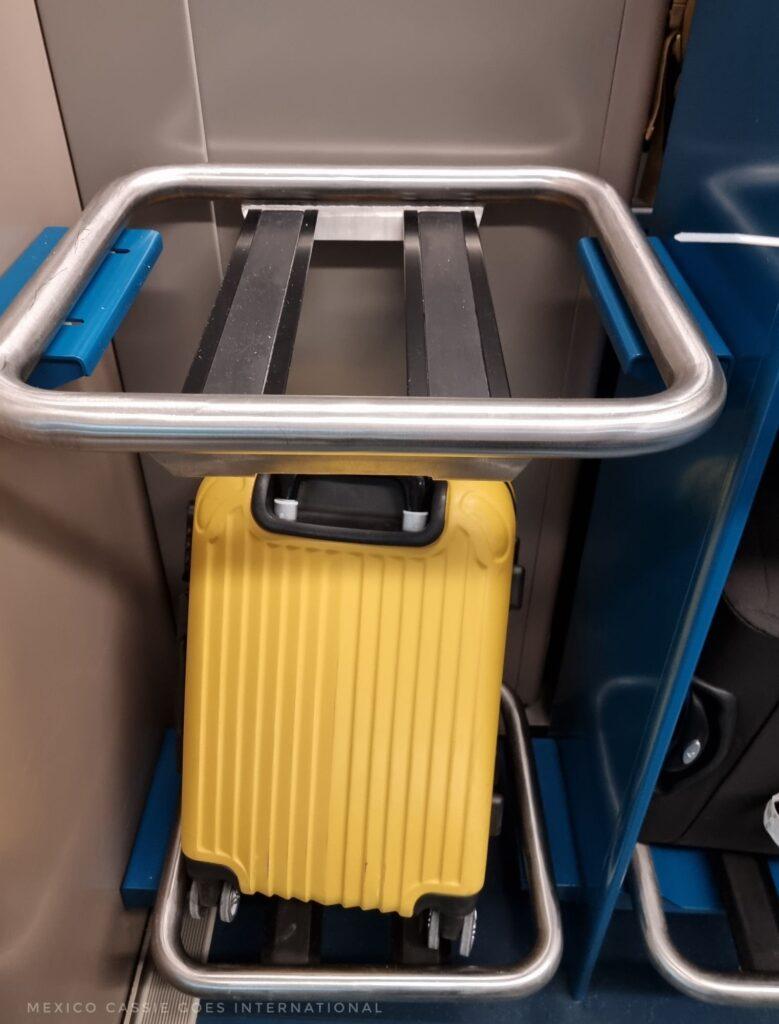 yellow suitcase sitting on a luggage rack