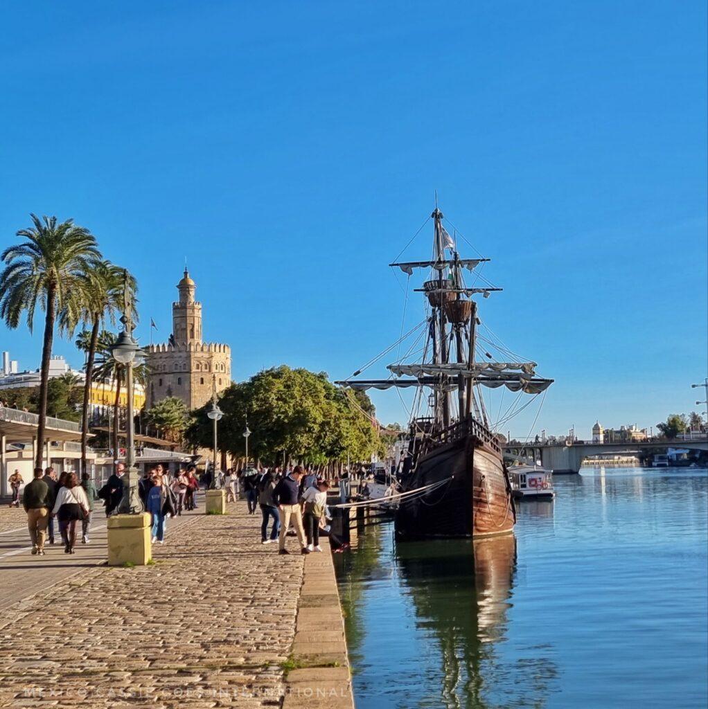 view of replica 16 century wooden boat sitting on calm river on sunny day