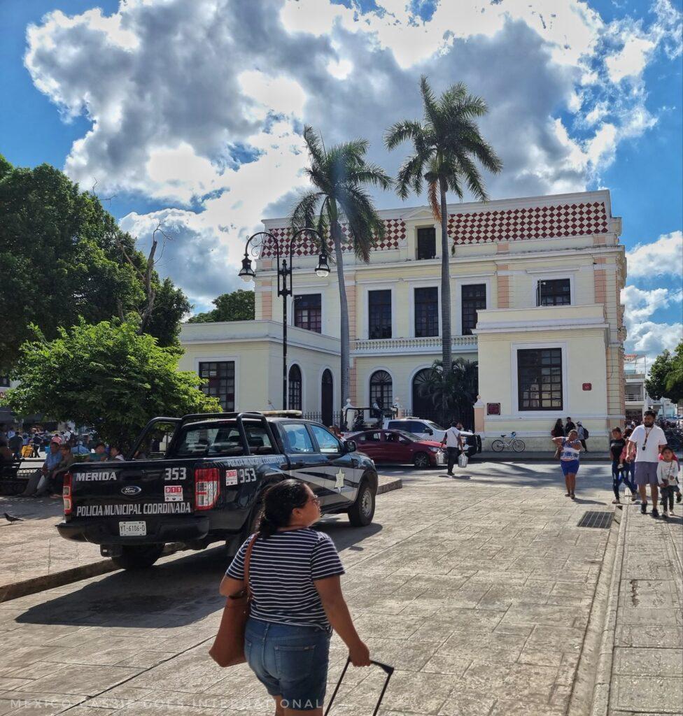woman pulling a suitcase, Museo de la Ciudad building in distance