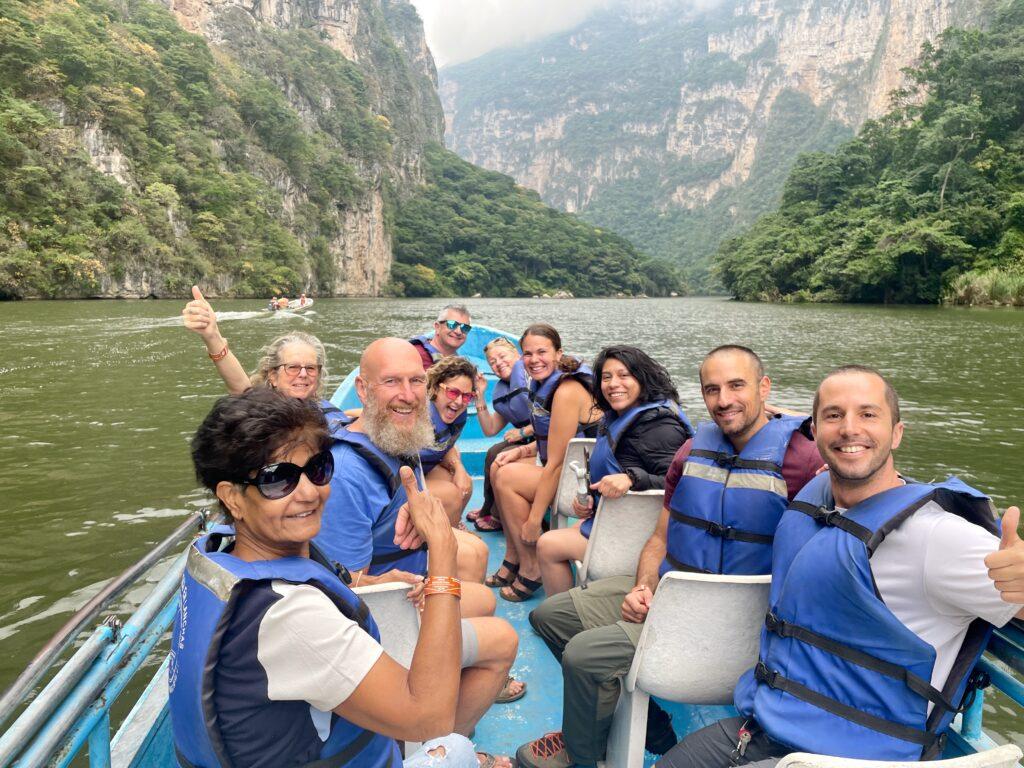 group of people on a boat all smiling at the camera