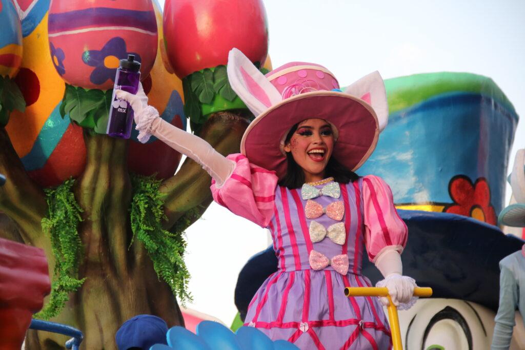 woman dressed in costume for carnaval - probably from Alice in Wonderland as she has white bunny ears