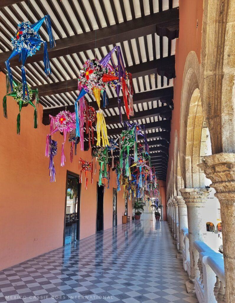 outdoor corridor, wooden beamed ceiling, piñatas hanging down