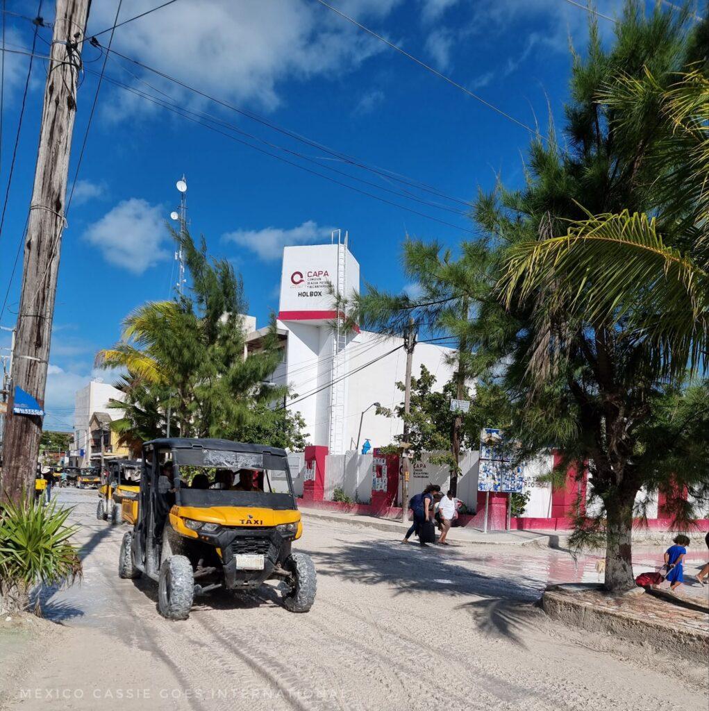 yellow golf cart on a sandy road