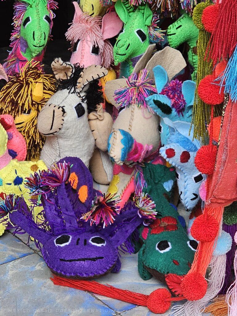 close up of handmade toys including a purple axolotl