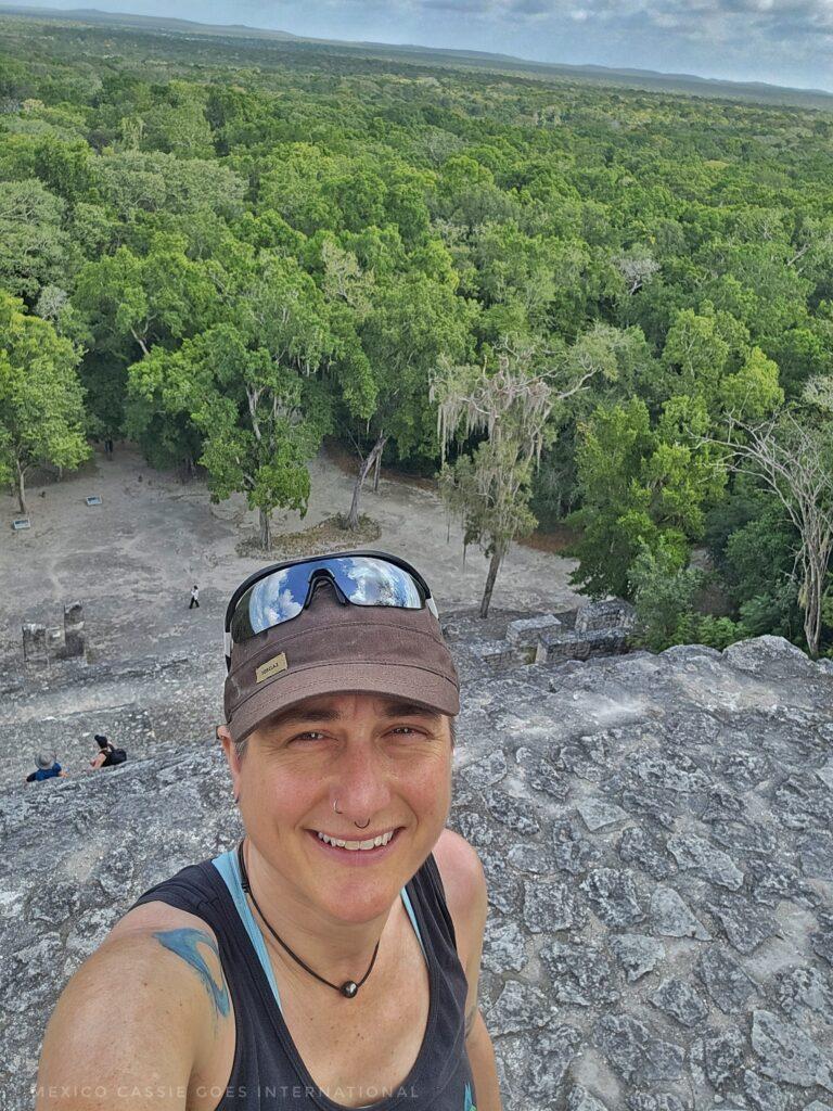 Cass in a black tshirt and brown cap standing at top of a pyramid