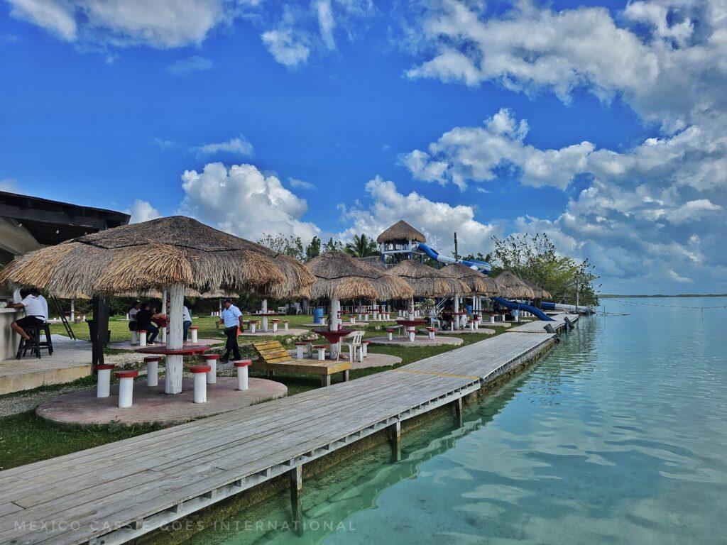 view along the side of the balnerario - wooden walk way,  palapas, gorgeous turquoise water