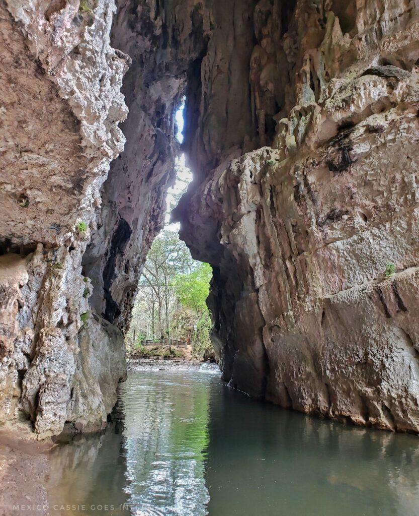 view through an opening in the rocks, shallow river at base