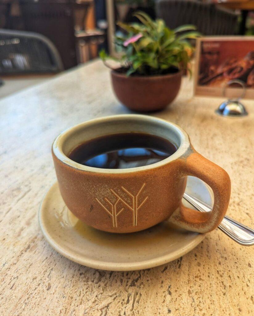 cup of black coffee in a pottery cup on a table