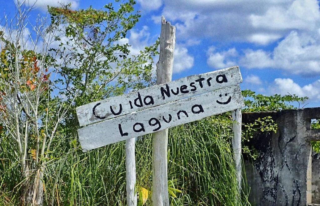 white sign that reads, "cuida nuestra laguna"
