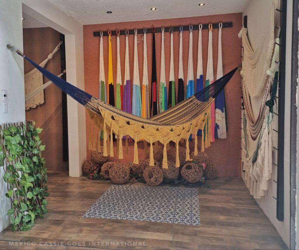 very smart hammock hanging (it has fancy  tassles) across the space, other hammocks hanging beautifully on the back wall 