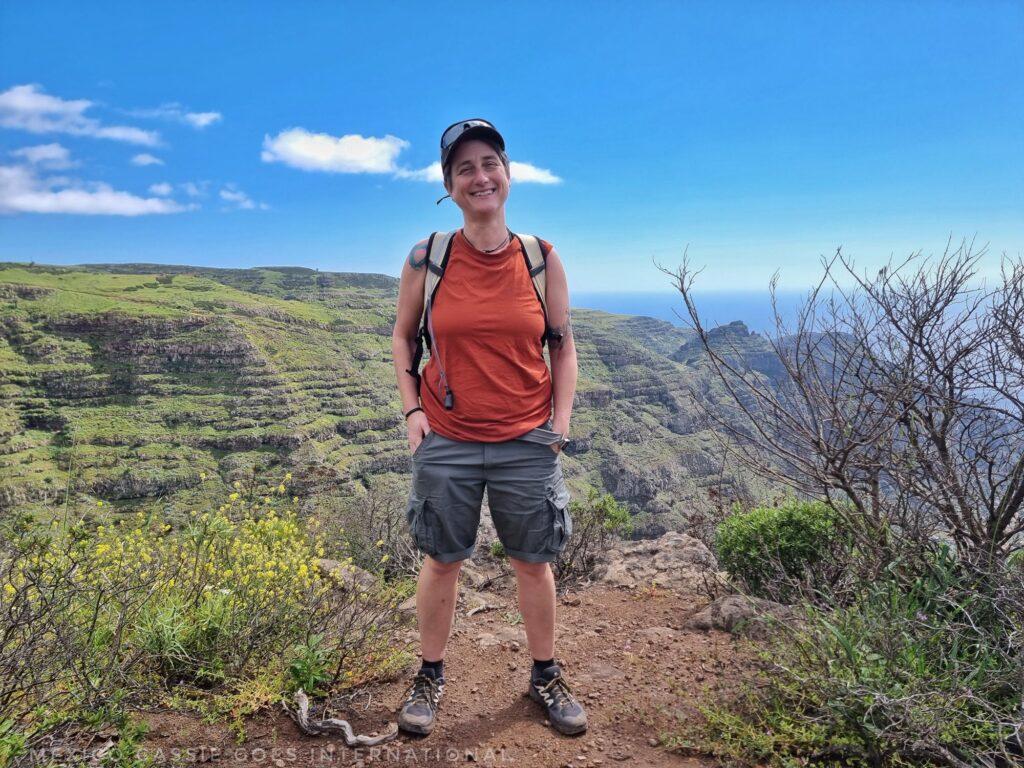 person standing at a mirador facing the camera - view of valley behind