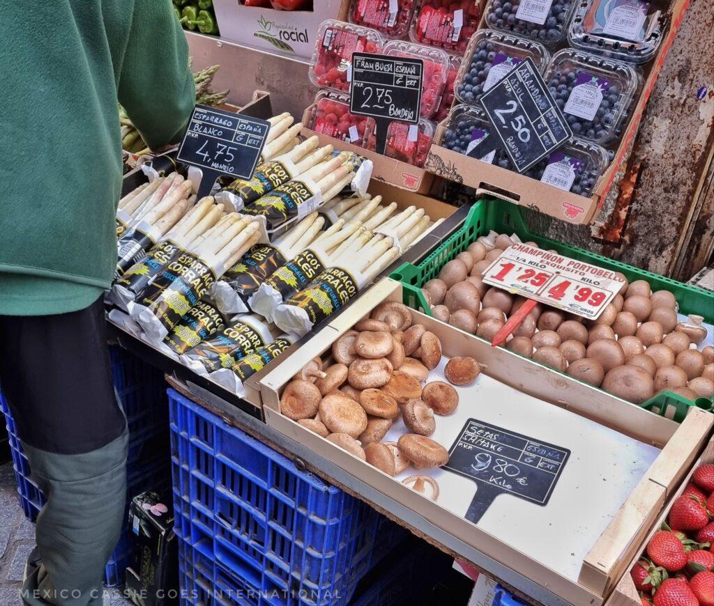close up of mushrooms and white asparagus in a market