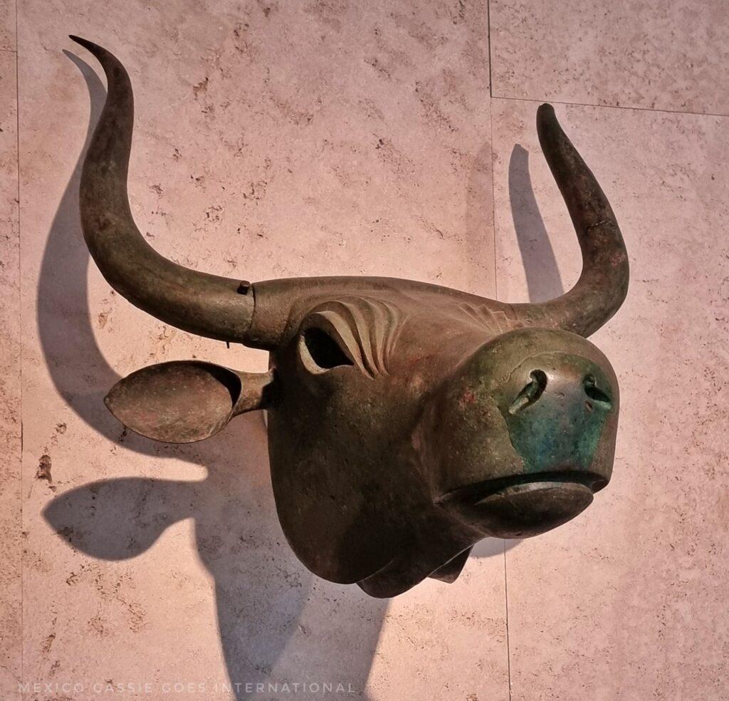 iron bull head with large horns mounted on wall. clear shadow