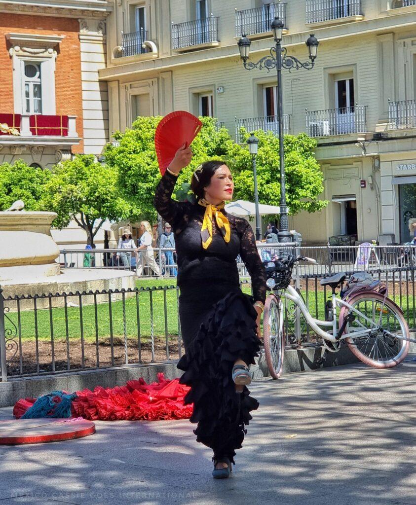 flamenco dancer on the street in Sevilla - black dress, red fan