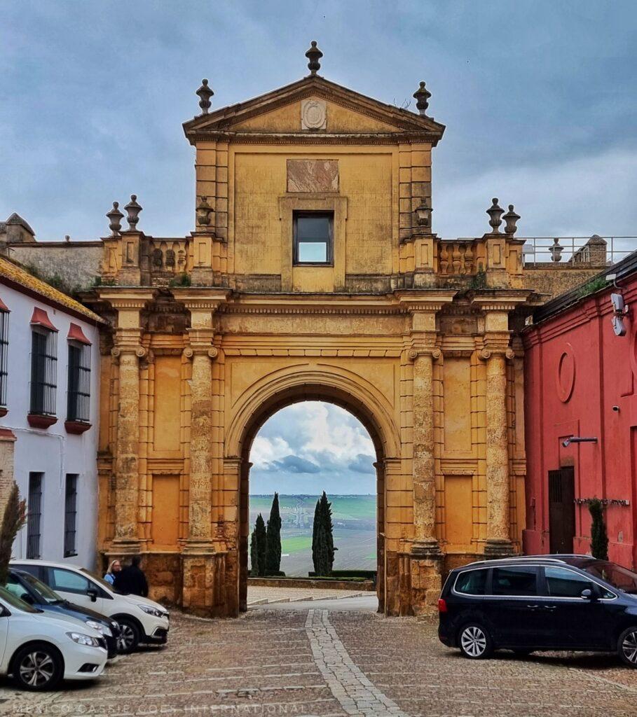 City gate in Carmona, cars parked outside it