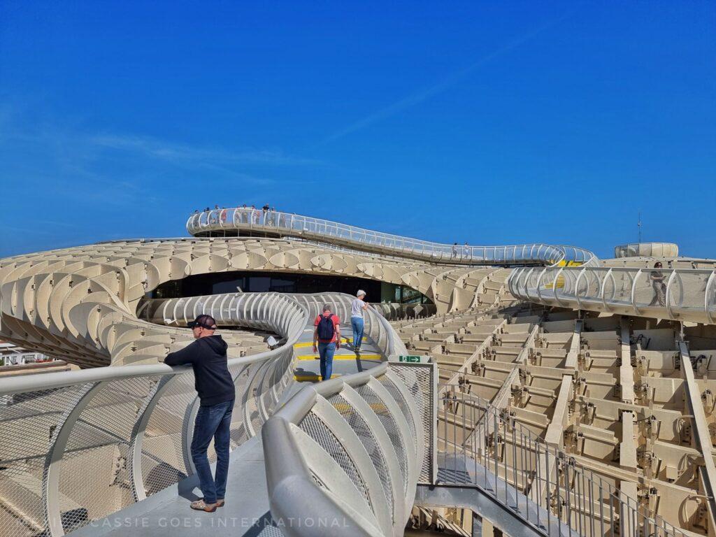 view of las setas from the top - people on walk way, blue sky, wooden criss crossed structure