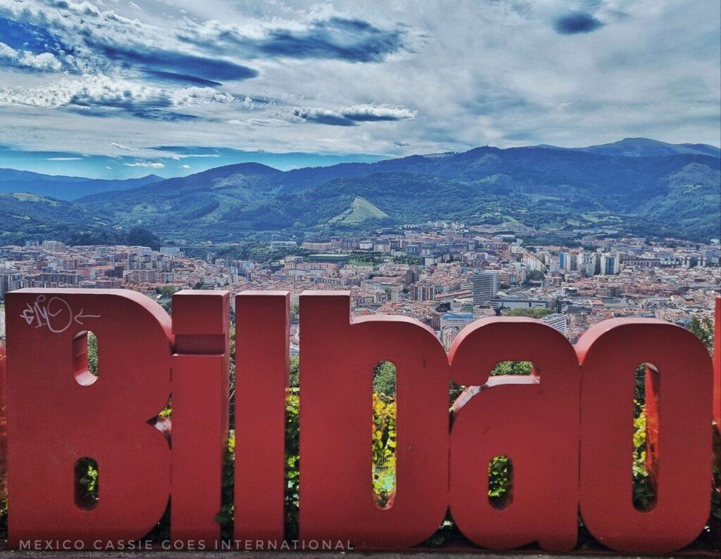 red Bilbao letters with view of city and hills behind