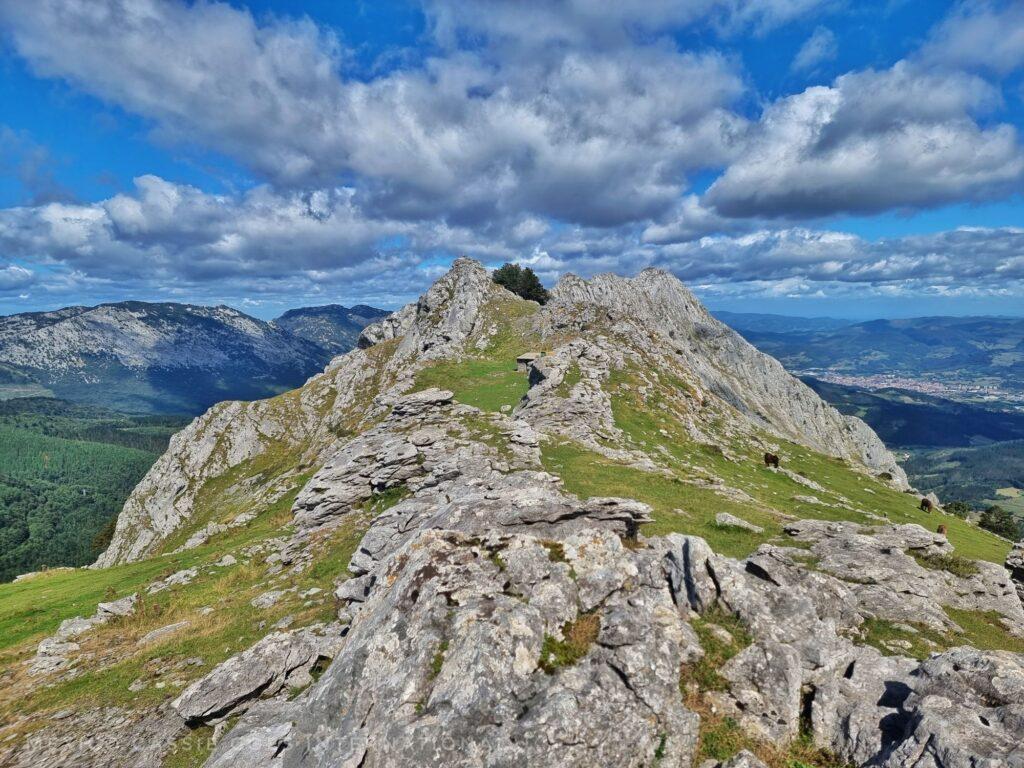 mountain top (with grass and rock), blue sky with cloud
