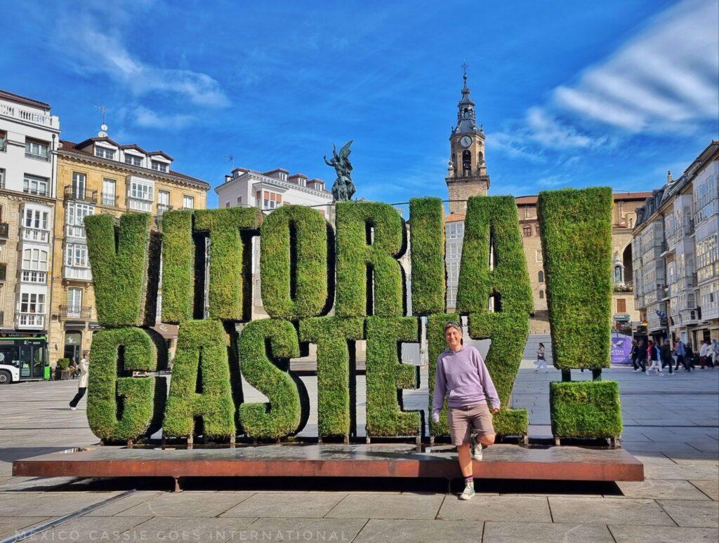 MexicoCassie standing in front of the green Vitoria Gasteiz sign