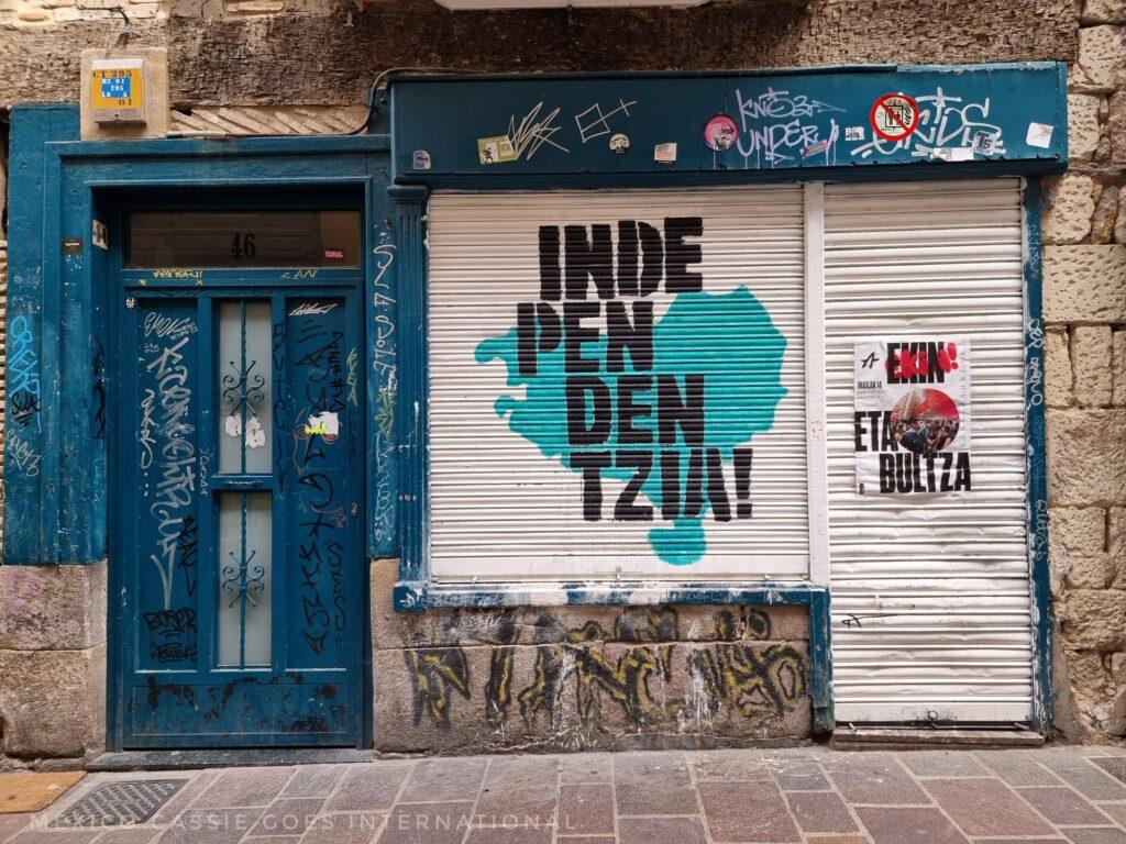 white painted window cover with green Basque Country map and word "independentzia!" in black
