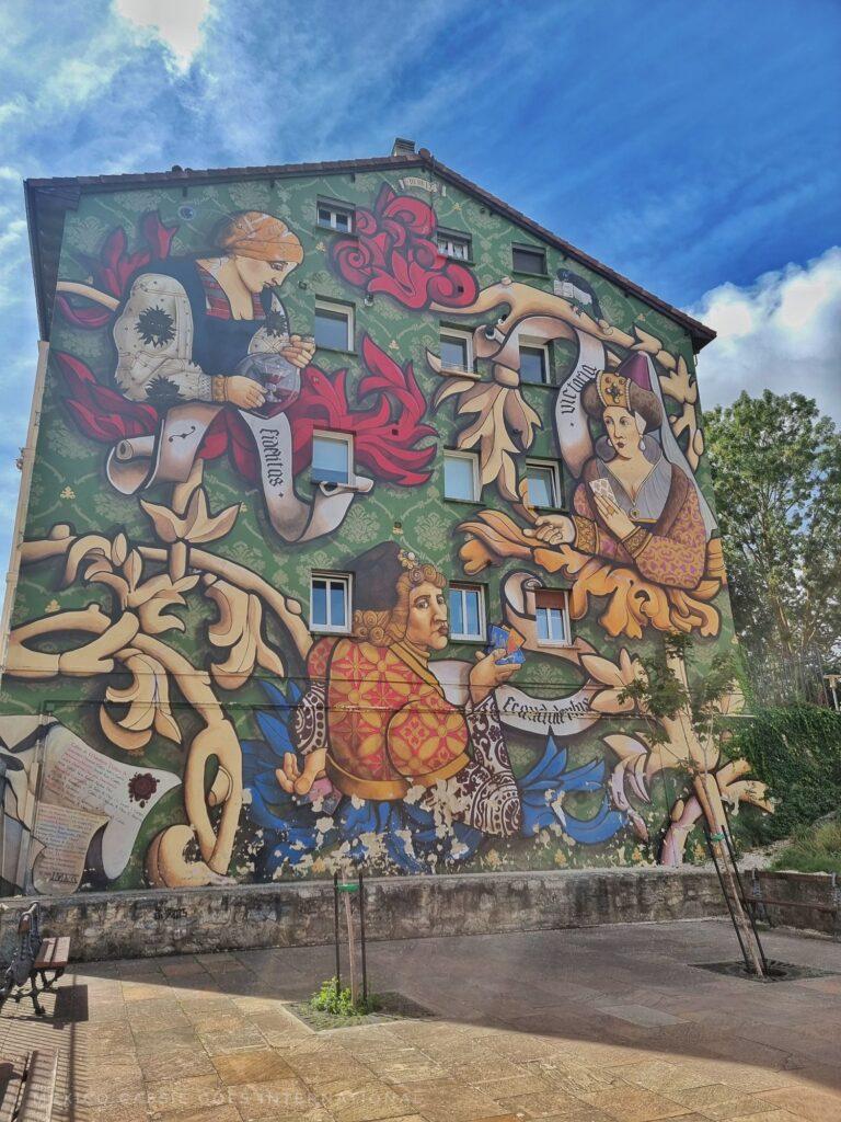 wall painted with 3 card playing medieval people 