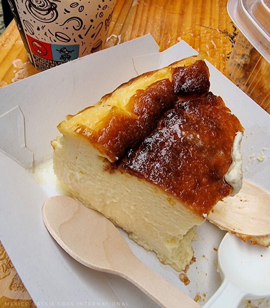 half eaten slice of cheesecake with 2 wooden spoons next to it