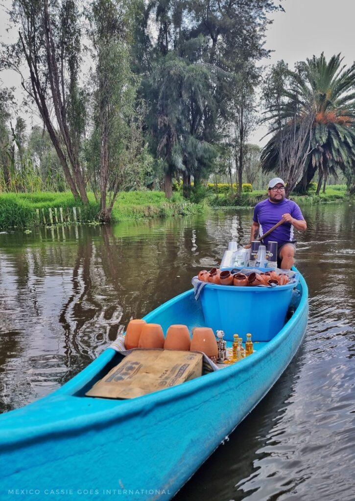 blue kayak with man selling drinks from it