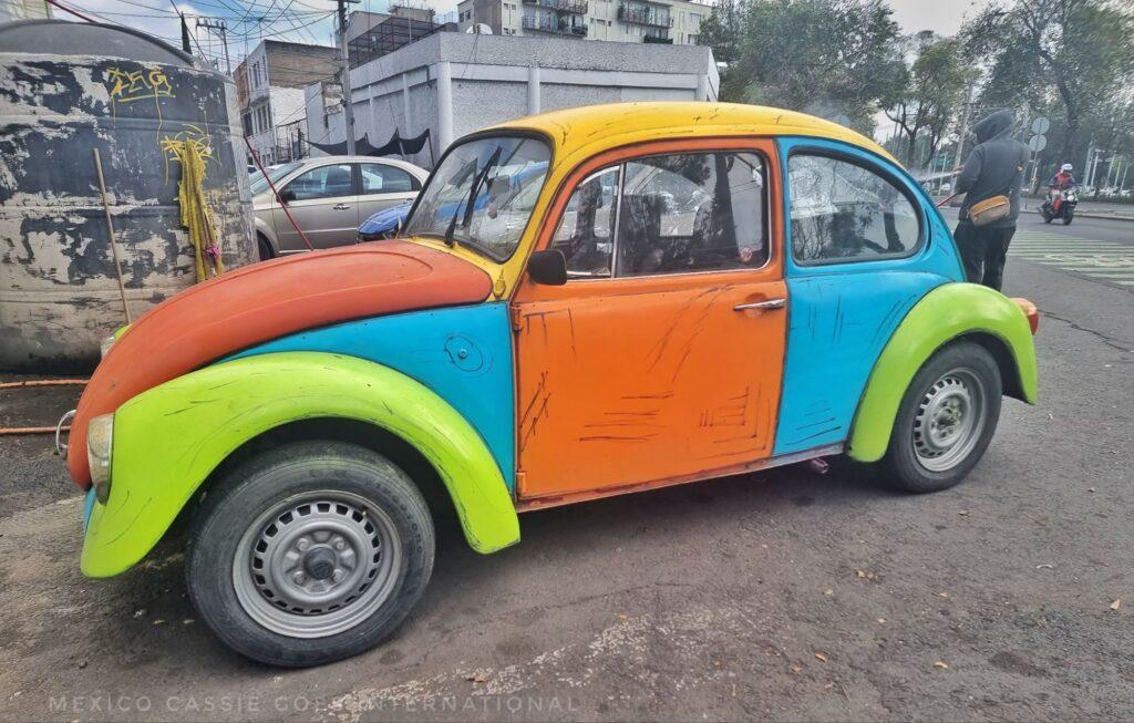 brightly coloured VW beetle - every panel is a different colour (red, green, yellow, blue)