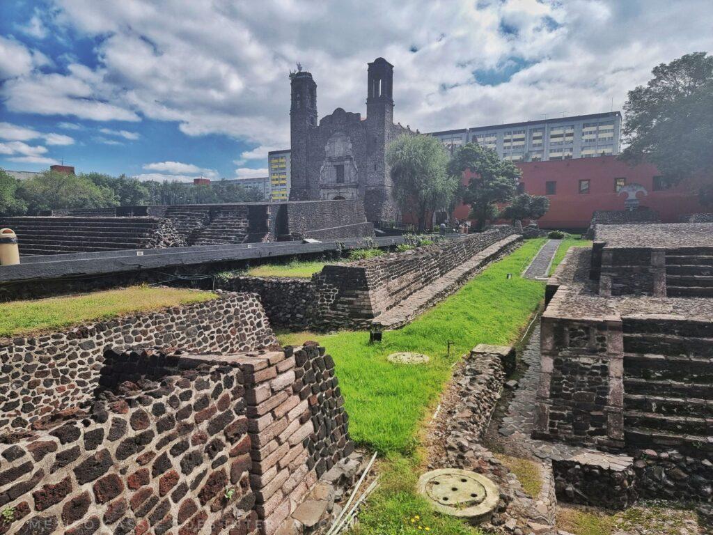 neatly restored ruined aztec town with catholic church in background