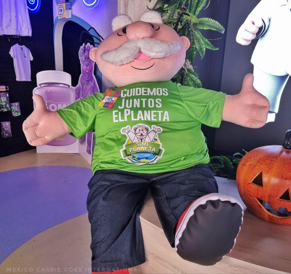 a giant Dr Simi plushie wearing a green tshirt
