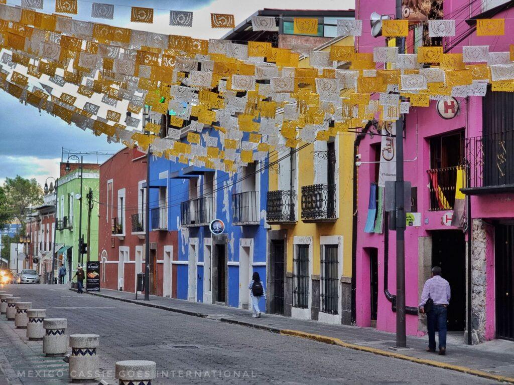 colourful buildings on street - yellow and white bunting across the road