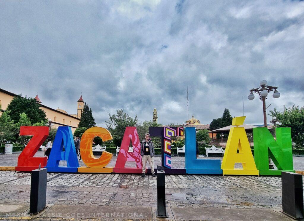 Zacatlán lettes on the plaza, Cass standing in front on a cloudy day