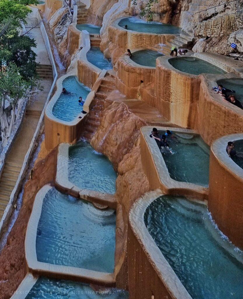 multiple pools with very few people in them, very blue water